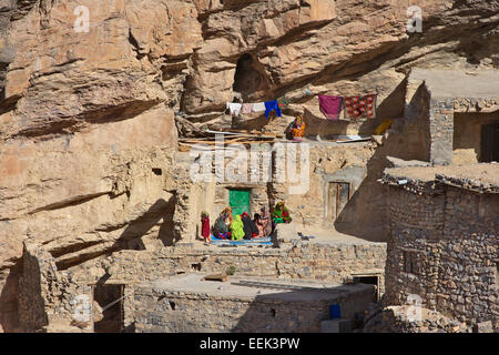 Omanische Frauen außerhalb ein traditionelles Steinhaus in einem kleinen Klippe Weiler im Jebel Akhdar Gebirge Oman entspannend. Stockfoto