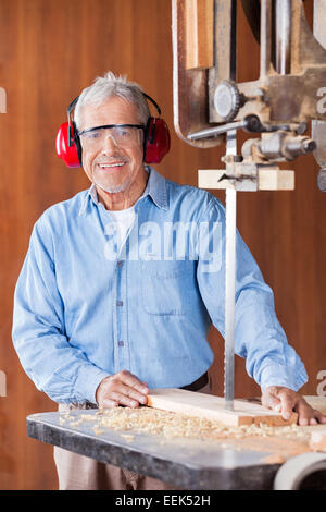 Gerne Tischler Schneiden von Holz mit Bandsäge Stockfoto