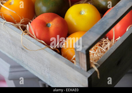 bunte Tomaten in Holzkiste Stockfoto