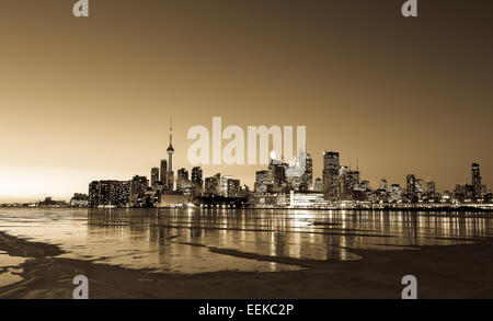 Die Skyline von Toronto im Winter aus dem Osten bei Sonnenuntergang mit den zugefrorenen See und Flecken von Schnee auf dem Eis Stockfoto