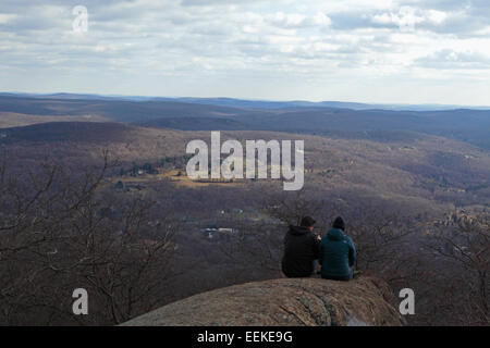 Zwei Wanderer machen Sie eine Pause und schauen Sie sich die Ansicht in den Hudson Highlands State Park im Herbst Stockfoto