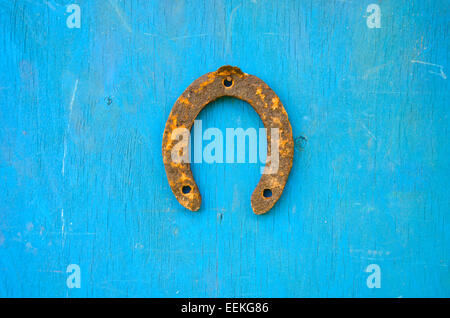 eine rostige alte Hufeisen Glück Symbol auf alte Holzwand Stockfoto