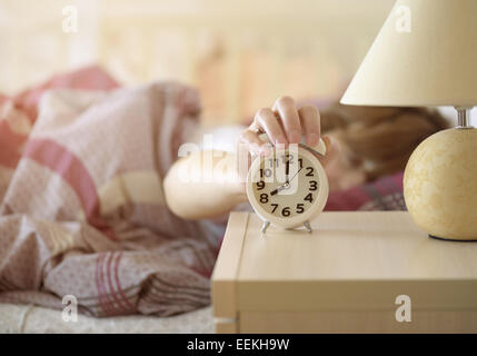 Mädchen schaltet der Wecker aufwachen am Morgen von einem Aufruf Stockfoto
