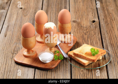 Gekochten Eiern in hölzernen Eierbecher mit toast Stockfoto