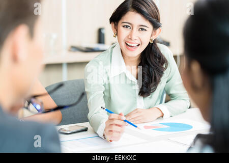 Finanzberater der indonesischen Ethnie im Büro sprechen Zahlen Stockfoto