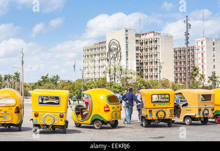 Sehenswürdigkeiten Transport: Gelb coco Taxis an das Ministerium des Innern Gebäude wartet mit Bild von Che Guevara, Plaza de la Revolución in Havanna Kuba Stockfoto