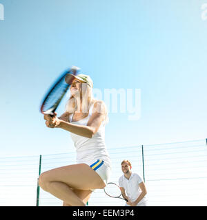 Jung verheiratet paar Tennis spielen in weißen Sportwear auf dem Tennisplatz draußen im Sommer Stockfoto