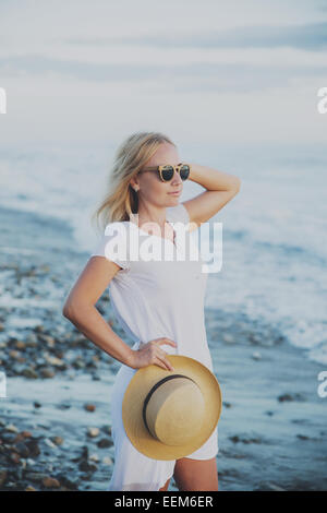 Frau mit Sonnenbrille Strand Hut festhalten Stockfoto