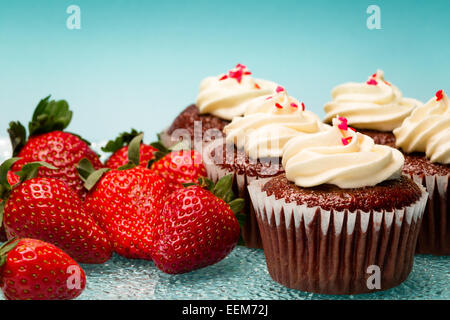 Frische Erdbeeren und rote samt-kleine Kuchen mit Schlagsahne Stockfoto