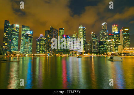 Skyline am Wasser mit beleuchteten Wolkenkratzern vom Hafen in Singapur aus gesehen Stockfoto