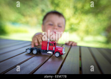 Porträt eines jungen spielen mit roten Spielzeug-LKW Stockfoto