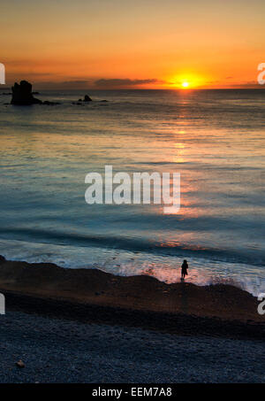 Spanien, Asturien, Playa del Silencio, Seestück und Silhouette Person bei Sonnenuntergang Stockfoto