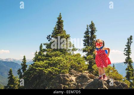 Mädchen gekleidet als Superheld auf einem Berg, USA Stockfoto