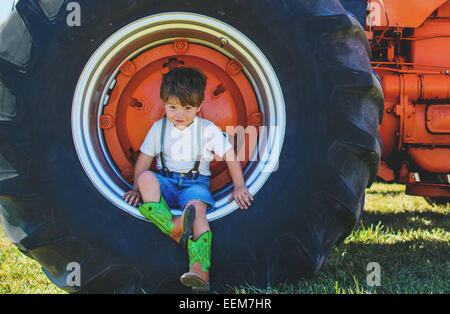 Junge auf einem Traktorreifen auf einem Bauernhof, USA Stockfoto