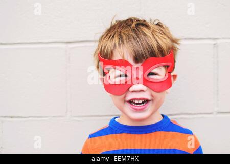Porträt eines lächelnden Jungen mit Superhelden-Maske Stockfoto