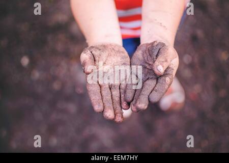 Ansicht von oben eines Jungen, der seine schmutzigen Hände zeigt Stockfoto