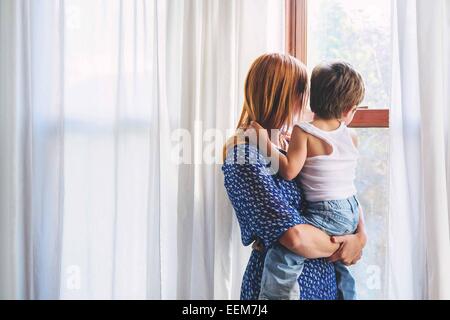 Mutter und ihr Sohn und Blick durch ein Fenster Stockfoto
