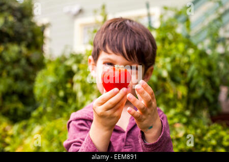 Gemischte Rassen junge bewundern frisches Obst im Garten Stockfoto