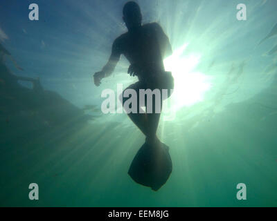 Silhouette eines Mannes Schwimmen im Meer Stockfoto