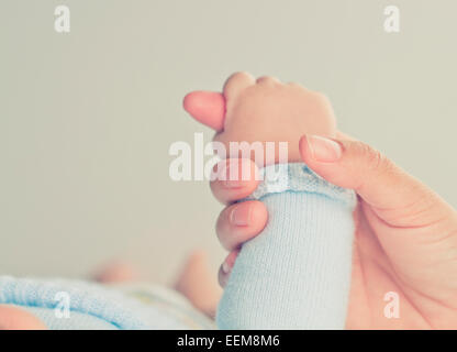 Nahaufnahme der Hand einer Mutter, die die Hand eines Jungen hält Stockfoto