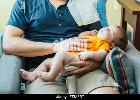 Kaukasische Vater Holding schlafenden Baby junge im Sessel Stockfoto