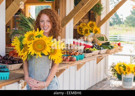 Kaukasische Frau mit Sonnenblumen am Bauernmarkt Stockfoto