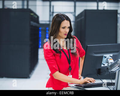 Kaukasische Geschäftsfrau mit Computer im Serverraum Stockfoto