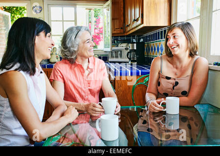 Kaukasische Mutter und Töchter Kaffeetrinken in Küche Stockfoto