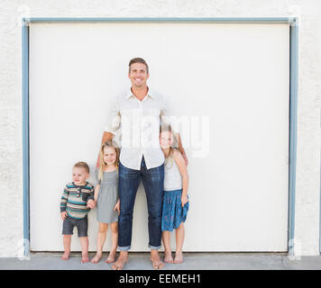 Kaukasische Vater und Kinder Lächeln in Einfahrt Stockfoto