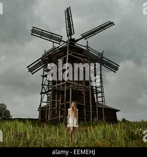 Kaukasische Teenager-Mädchen stehen unter hölzerne Windmühle Stockfoto