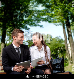 Young Business paar auf der Bank sitzen und machen Selfie Foto mit Tabletten Stockfoto
