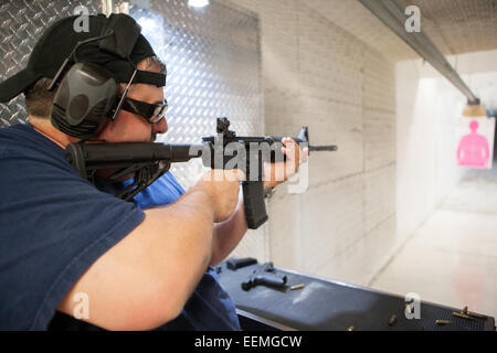 Mann-Zielschießen mit Sturmgewehr auf eine indoor Pistole Bereich in den USA Stockfoto