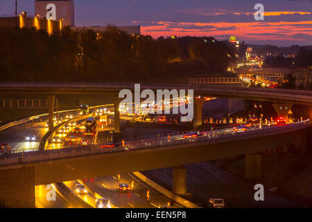 Rush Hour auf der Autobahn A40, Autobahn, auf "West-Kreuz" - Kreuzung west, in der Abenddämmerung, Bochum, Deutschland Stockfoto