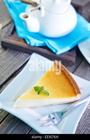 Käsekuchen auf weißen Teller und auf einem Tisch Stockfoto