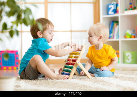 Kinder Jungen spielen mit abacus Stockfoto