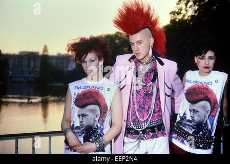 „Postkarte Punk“ Matt Belgrano trägt eine rosa Teddy Boy Drape Jacke und posiert mit zwei weiblichen Punks vor dem Buckingham Palace. London. Ca. 1980 Stockfoto