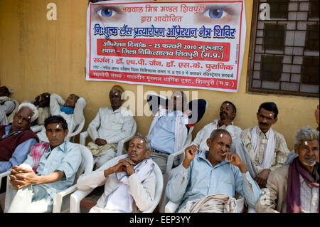 ländlichen Männer warten auf Vorsorgeuntersuchungen und Beratungen in einer Augenklinik, Shivpuri District Hospital, Shivpuri Madhya Pradesh, Indien Stockfoto