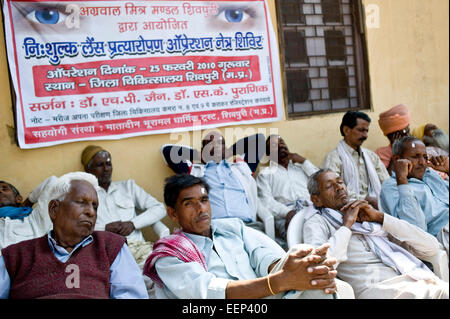 ländlichen Männer warten auf Vorsorgeuntersuchungen und Beratungen in einer Augenklinik, Shivpuri District Hospital, Shivpuri Madhya Pradesh, Indien Stockfoto