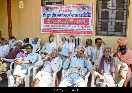 ländlichen Männer warten auf Vorsorgeuntersuchungen und Beratungen in einer Augenklinik, Shivpuri District Hospital, Shivpuri Madhya Pradesh, Indien Stockfoto