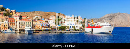 Panorama-Aufnahme der Hafen von Symi Griechenland mit der Fähre im Hafen. Griechenland in Europa. Stockfoto