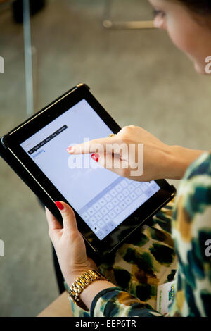 Frau mit roten Nägeln nutzt das iPad Stockfoto