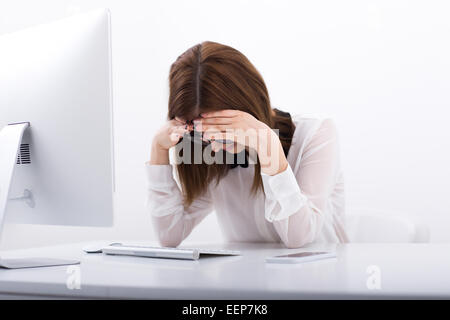 An ihrem Arbeitsplatz im Büro sitzen müde Geschäftsfrau Stockfoto