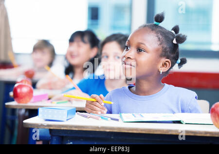 Reihe von Studenten in einem primären interracial Klassenzimmer. Afro Amerikanerin, die Aufmerksamkeit auf den Lehrer. Stockfoto