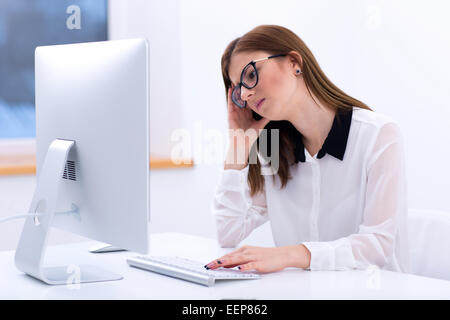 Müde Geschäftsfrau, die im Büro arbeiten Stockfoto