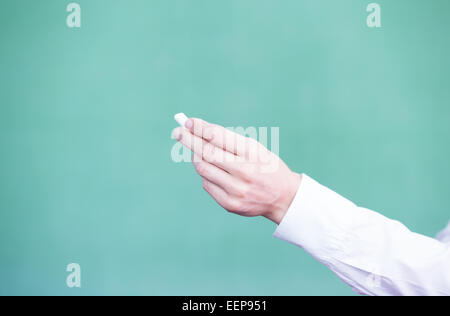 Weibliche Lehrer Hand mit Kreide vor leeren Tafel. Stockfoto