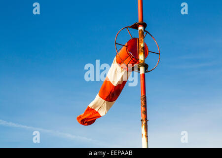 Windsack auf einem rostigen Mast zur Bestimmung der Windgeschwindigkeit und Windgeschwindigkeit auf ein Hubschrauberlandeplatz Stockfoto
