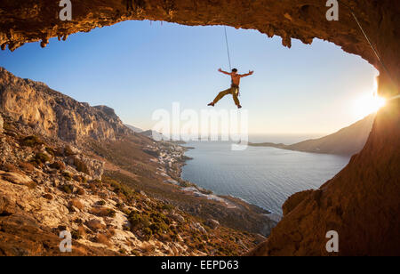 Kletterer hängen am Seil beim Vorstieg bei Sonnenuntergang Stockfoto