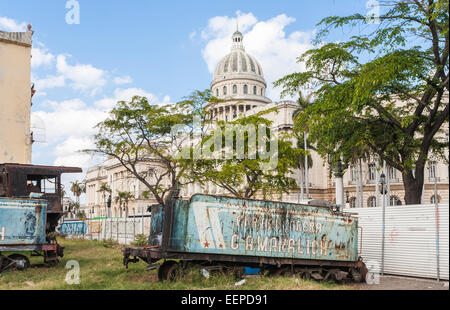 Blick auf die Kuppel der legendären nationalen Capitol Gebäude, die Altstadt von Havanna, Kuba hinter ein verfallenes, Rusty zug Ausschreibung in einem städtischen downtown Schrottplatz Stockfoto