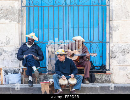 Drei ältere Buskers singen, spielen Gitarre und Schlagzeug (Bongos) auf dem Cathedral Square (Plaza De La Catedral), Alt-Havanna, Kuba Stockfoto