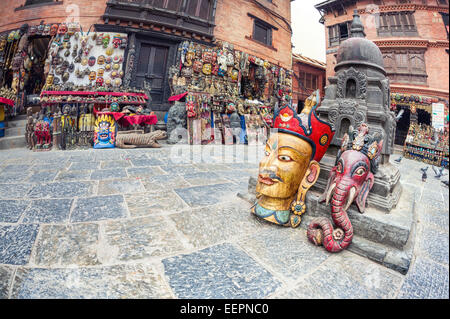 Großen Holzmasken in der Nähe von Souvenirläden auf dem Platz in der Nähe von Swayambhunath Stupa in Kathmandu-Tal, Nepal Stockfoto